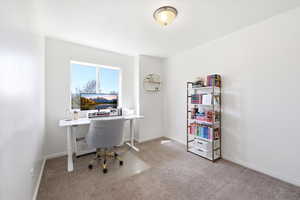 Office space with light colored carpet and baseboards