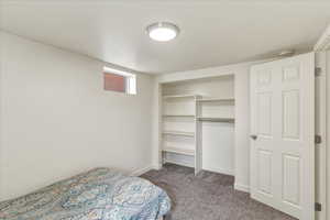 Unfurnished bedroom featuring dark colored carpet and a closet