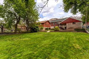 Back of property featuring a fenced backyard and concrete block siding