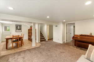 Game room with recessed lighting, light colored carpet, and a textured ceiling