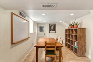 Dining space with light wood-style floors and recessed lighting