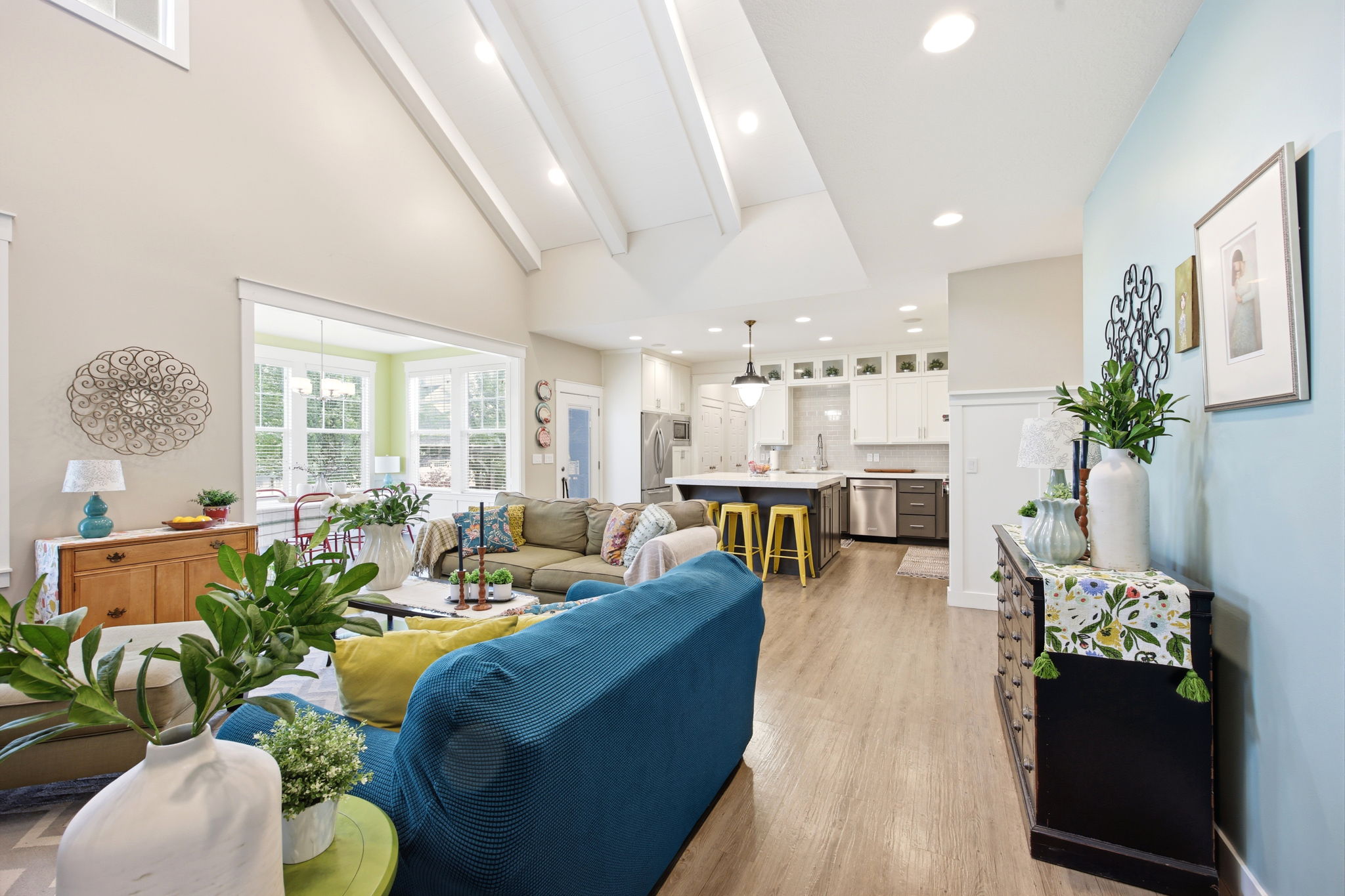 Living room featuring light wood-style flooring, vaulted ceiling, and recessed lighting