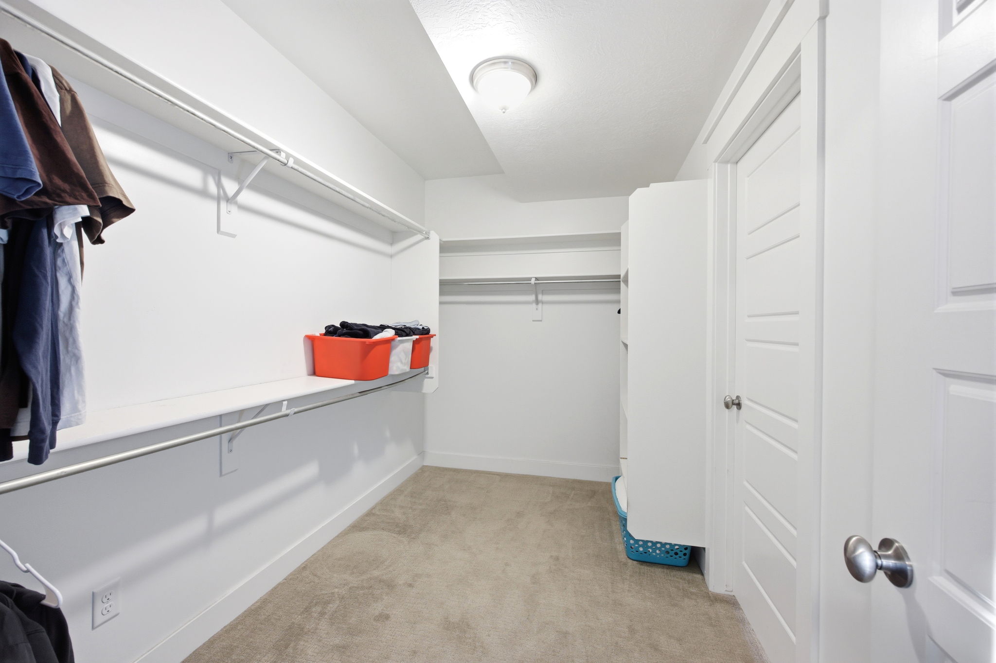 Walk in closet featuring light colored carpet