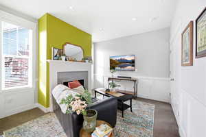 Carpeted bedroom featuring a decorative wall, a fireplace, recessed lighting, and wainscoting