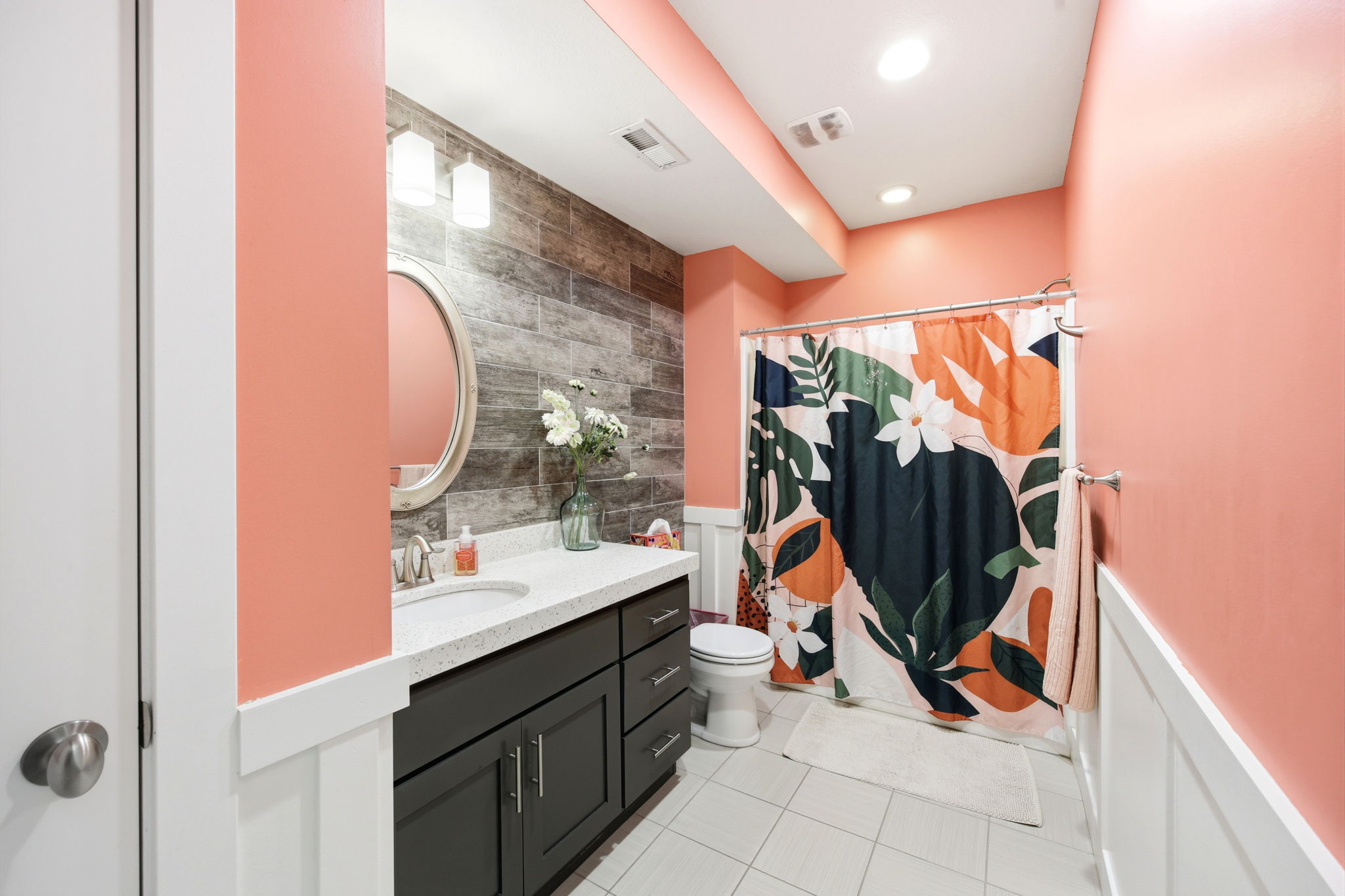 Full bathroom featuring vanity, wainscoting, a shower with shower curtain, and light tile patterned floors