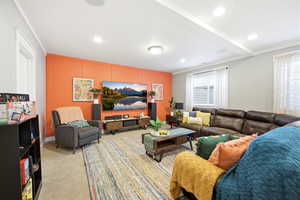 Living area featuring light colored carpet, crown molding, and recessed lighting