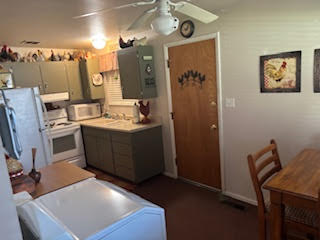 Kitchen featuring white appliances, ceiling fan, and light countertops