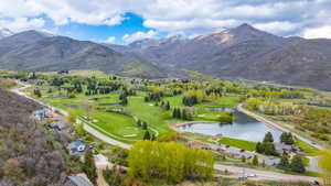 Drone / aerial view of a water and mountain view and a golf course