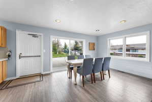 Dining area with plenty of natural light, a textured ceiling, light wood-style flooring, and recessed lighting