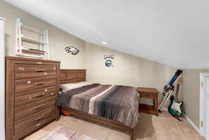 Bedroom with light carpet, vaulted ceiling, and recessed lighting