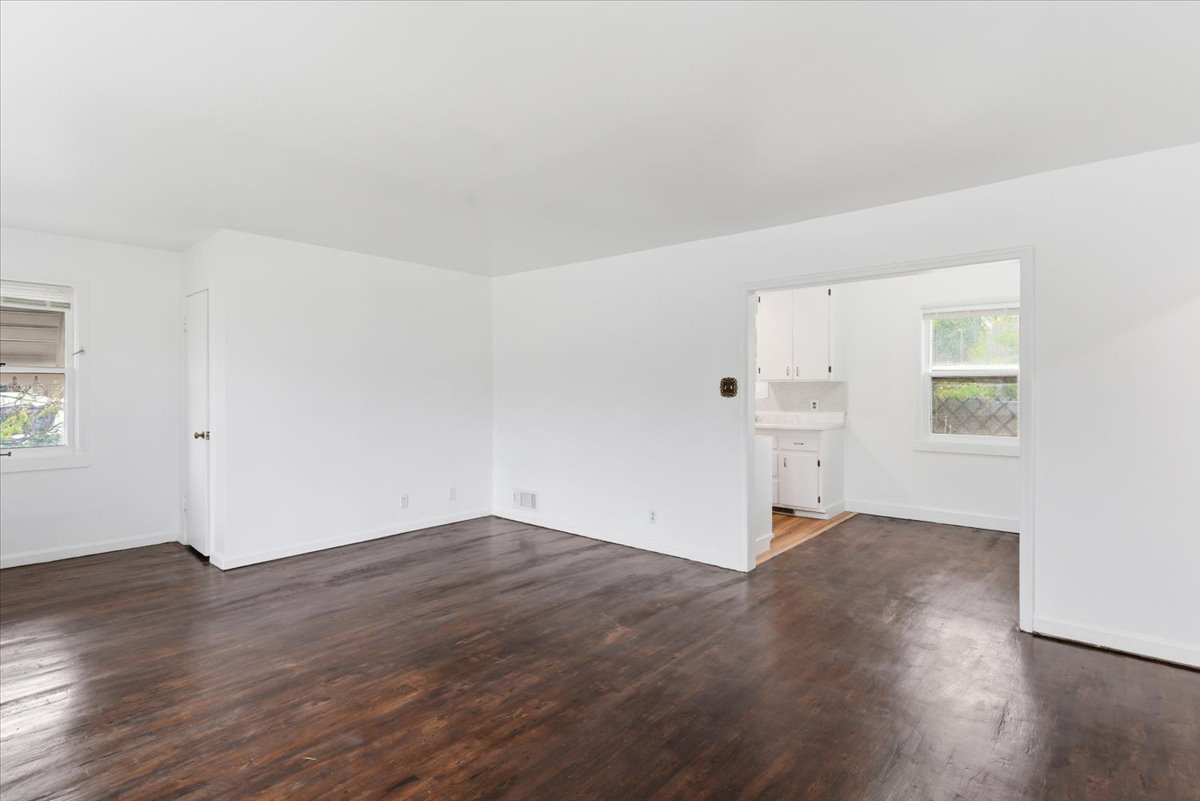 Empty room featuring plenty of natural light and dark wood finished floors