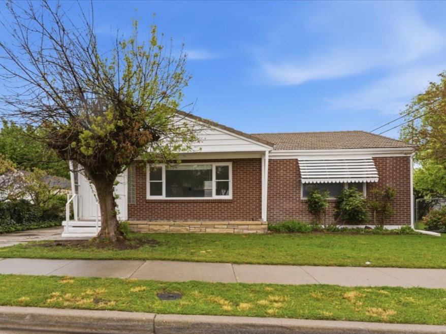 View of front of property with a front yard and brick siding