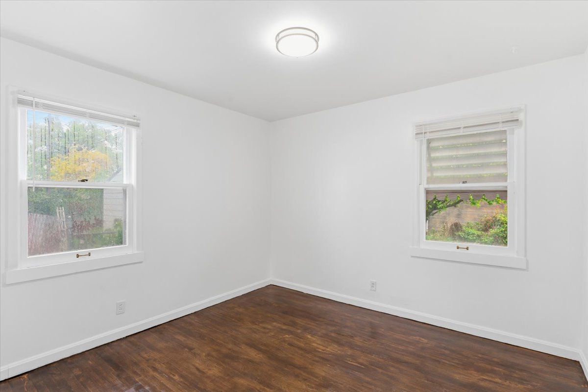 Unfurnished room featuring dark wood-style floors and plenty of natural light