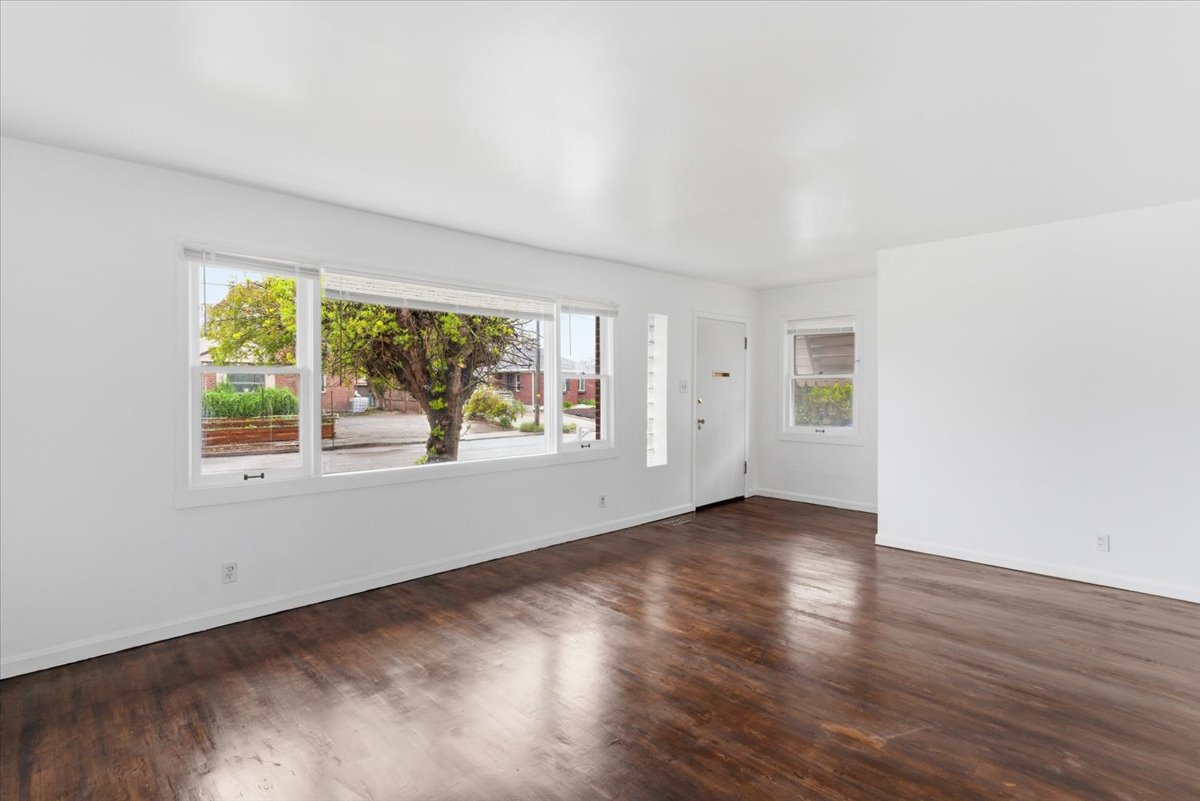 Empty room with dark wood finished floors and baseboards