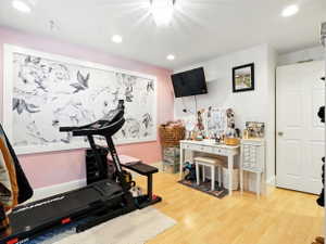 Exercise area featuring recessed lighting and light wood finished floors