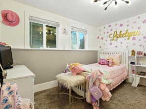 Bedroom featuring dark colored carpet and baseboards