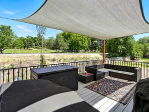Wooden terrace featuring view of wooded area
