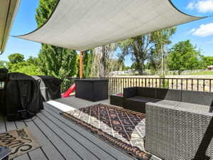 Wooden terrace featuring grilling area and outdoor furniture