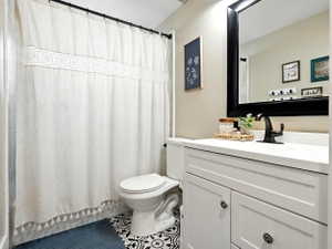 Full bathroom with vanity, a shower with shower curtain, and tile patterned flooring