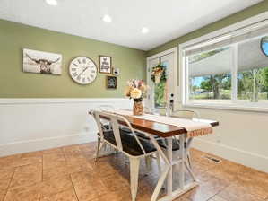 Dining space with wainscoting, recessed lighting, and a textured ceiling