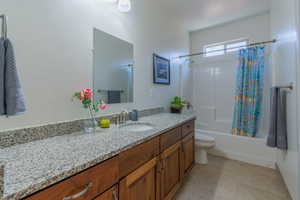 Bathroom with vanity, shower / tub combo with curtain, and light tile patterned flooring