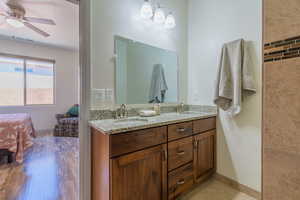 Bathroom with double vanity, a ceiling fan, and ensuite bathroom
