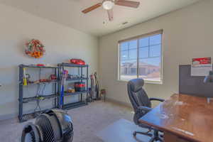 Office with light carpet and ceiling fan