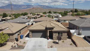 Mediterranean / spanish home with stone siding, an attached garage, a residential view, and driveway