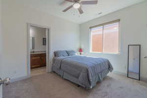 Bedroom featuring light colored carpet, a ceiling fan, and ensuite bathroom