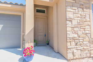 Property entrance with stone siding and stucco siding