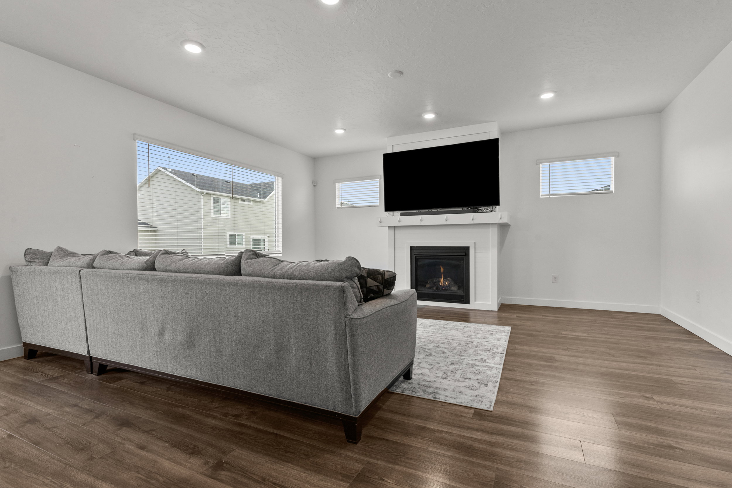 Living room featuring dark wood-style flooring, a lit fireplace, and recessed lighting