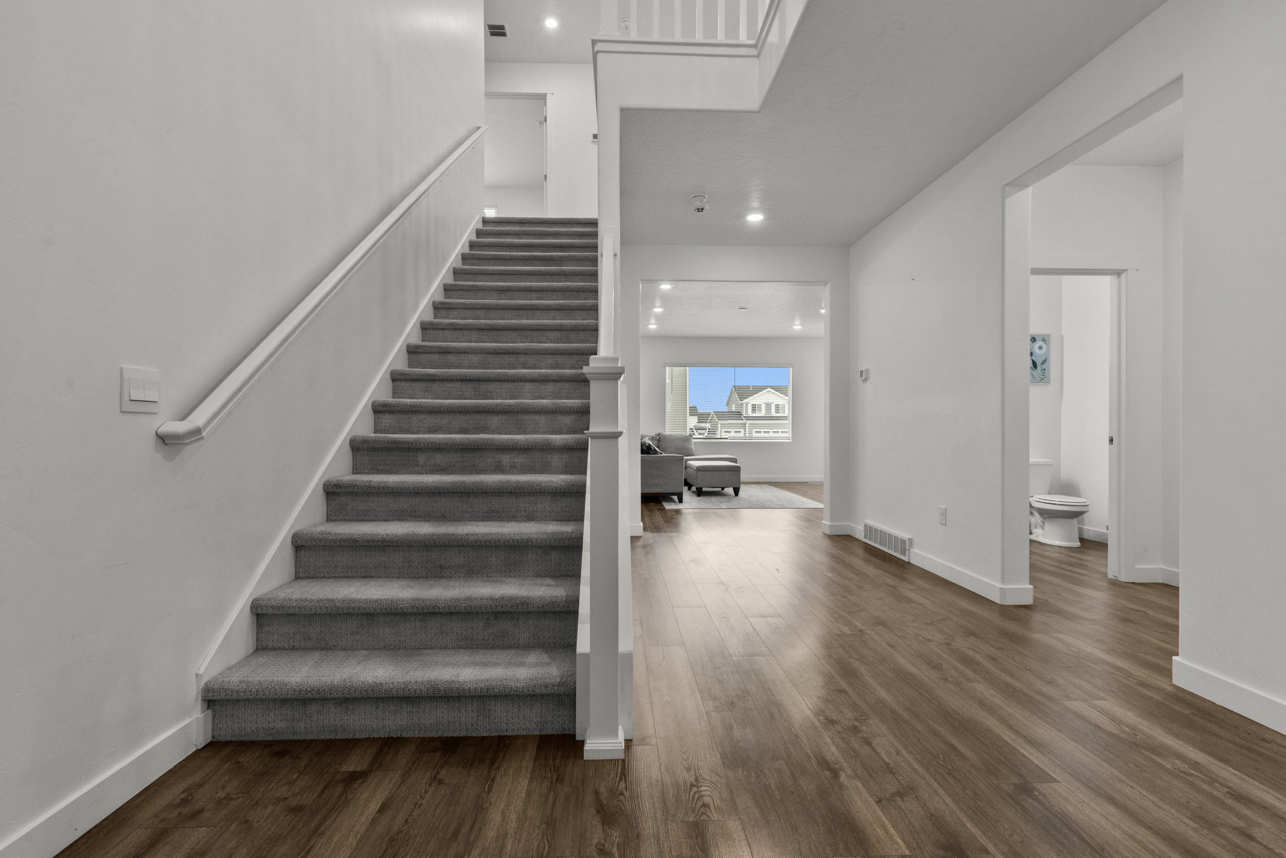 Staircase featuring wood finished floors and recessed lighting