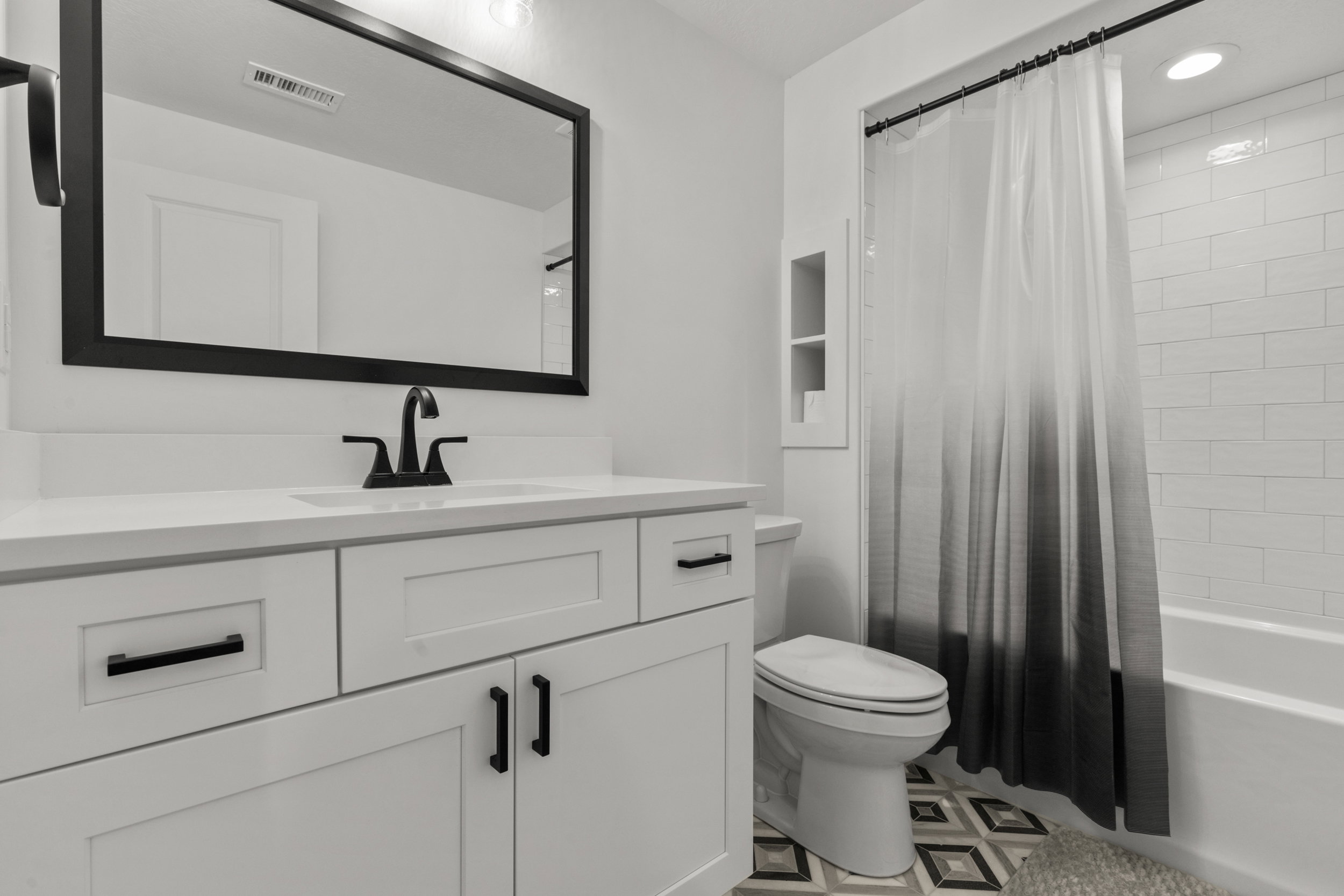 Bathroom featuring shower / bath combination with curtain, vanity, and recessed lighting