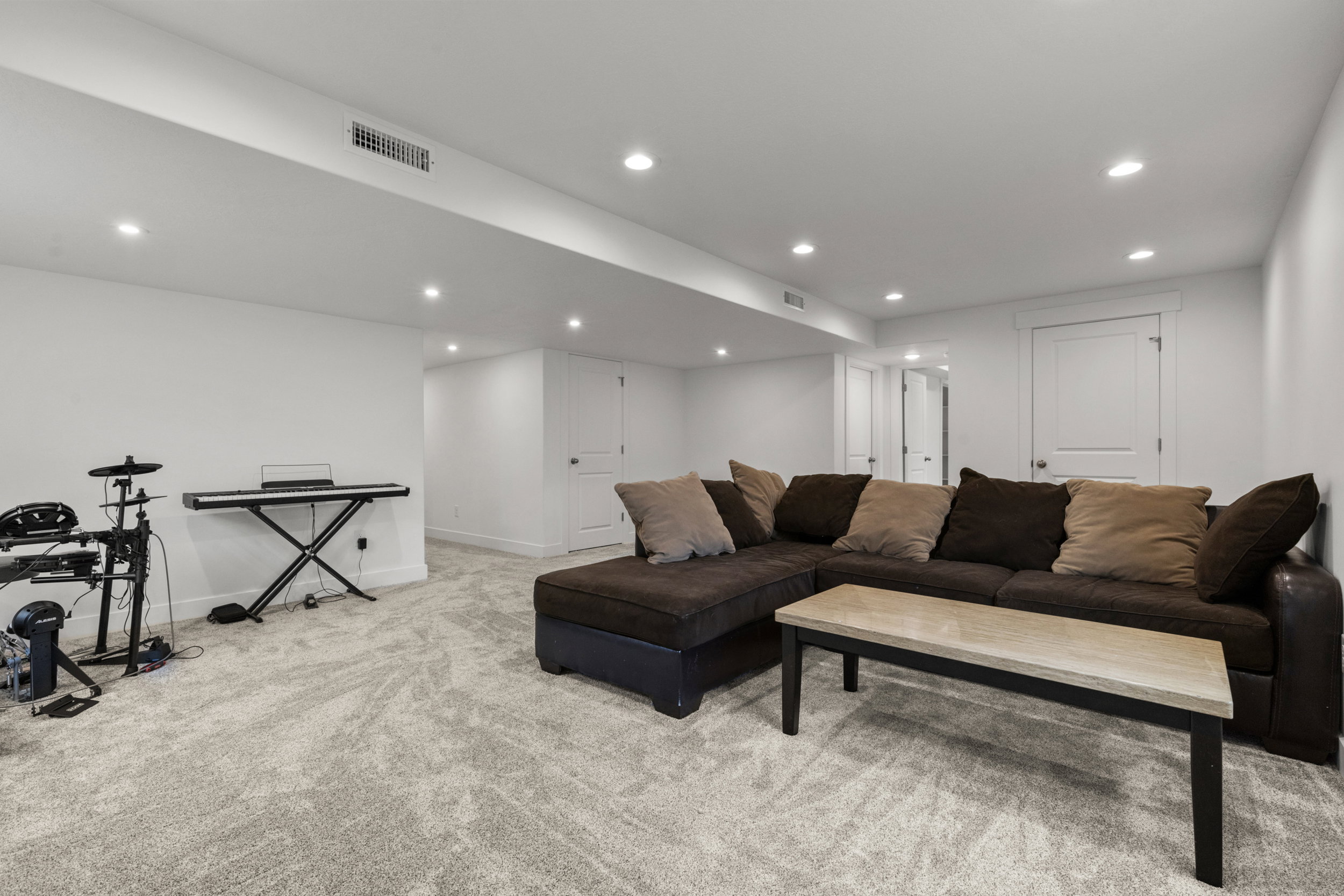 Living area with recessed lighting and light carpet