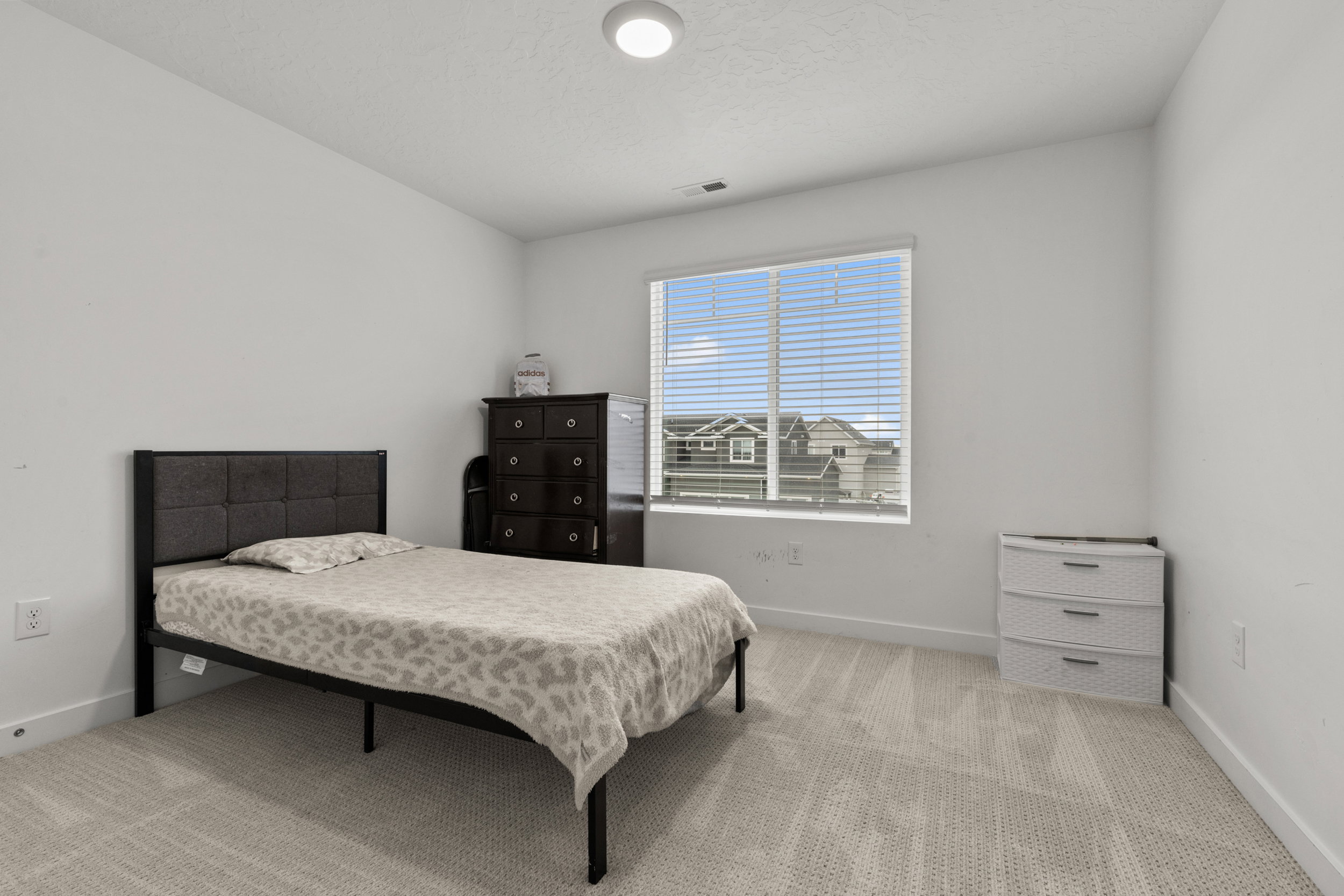 Bedroom with light colored carpet and baseboards