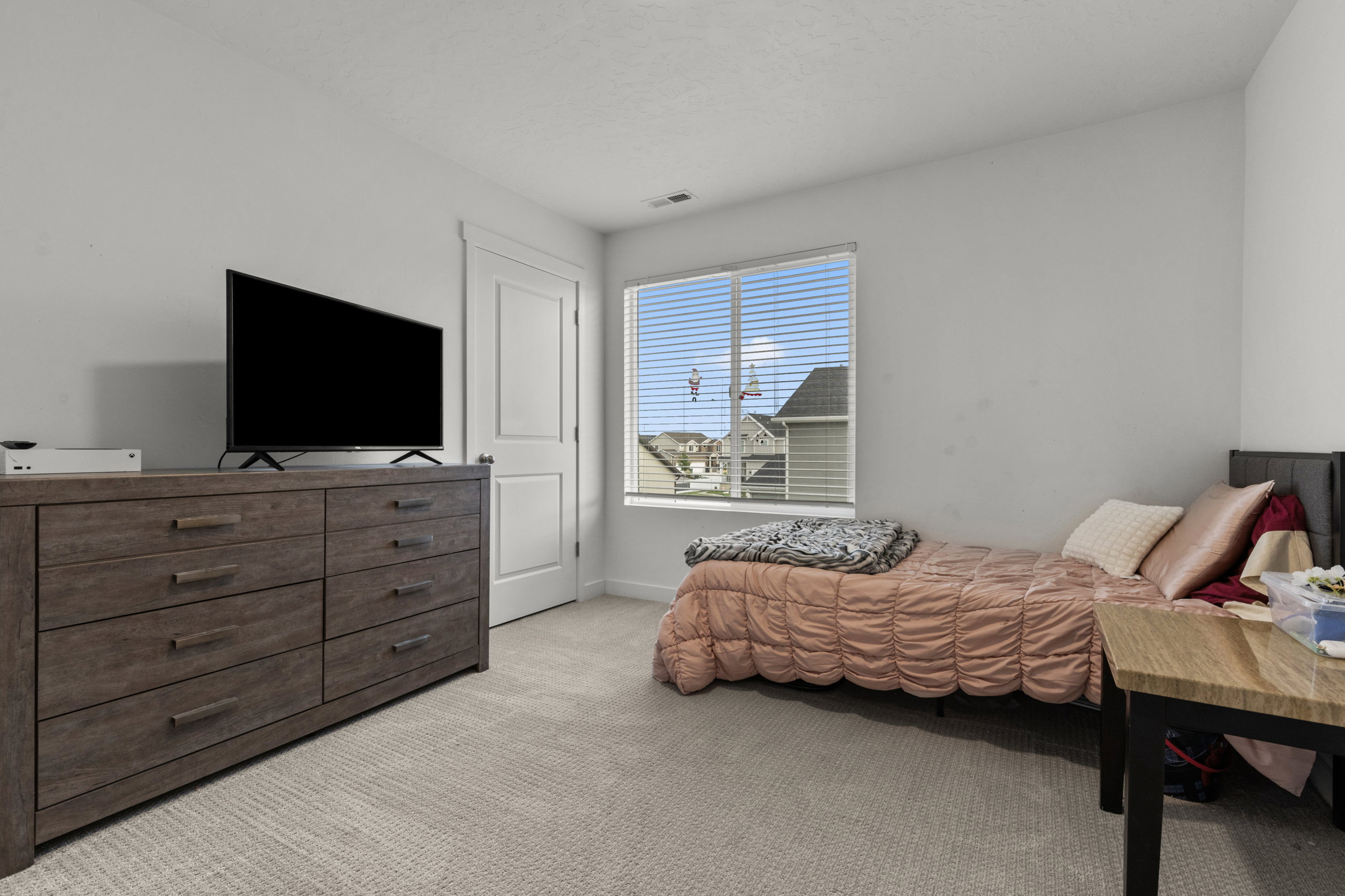 Bedroom with light colored carpet and baseboards