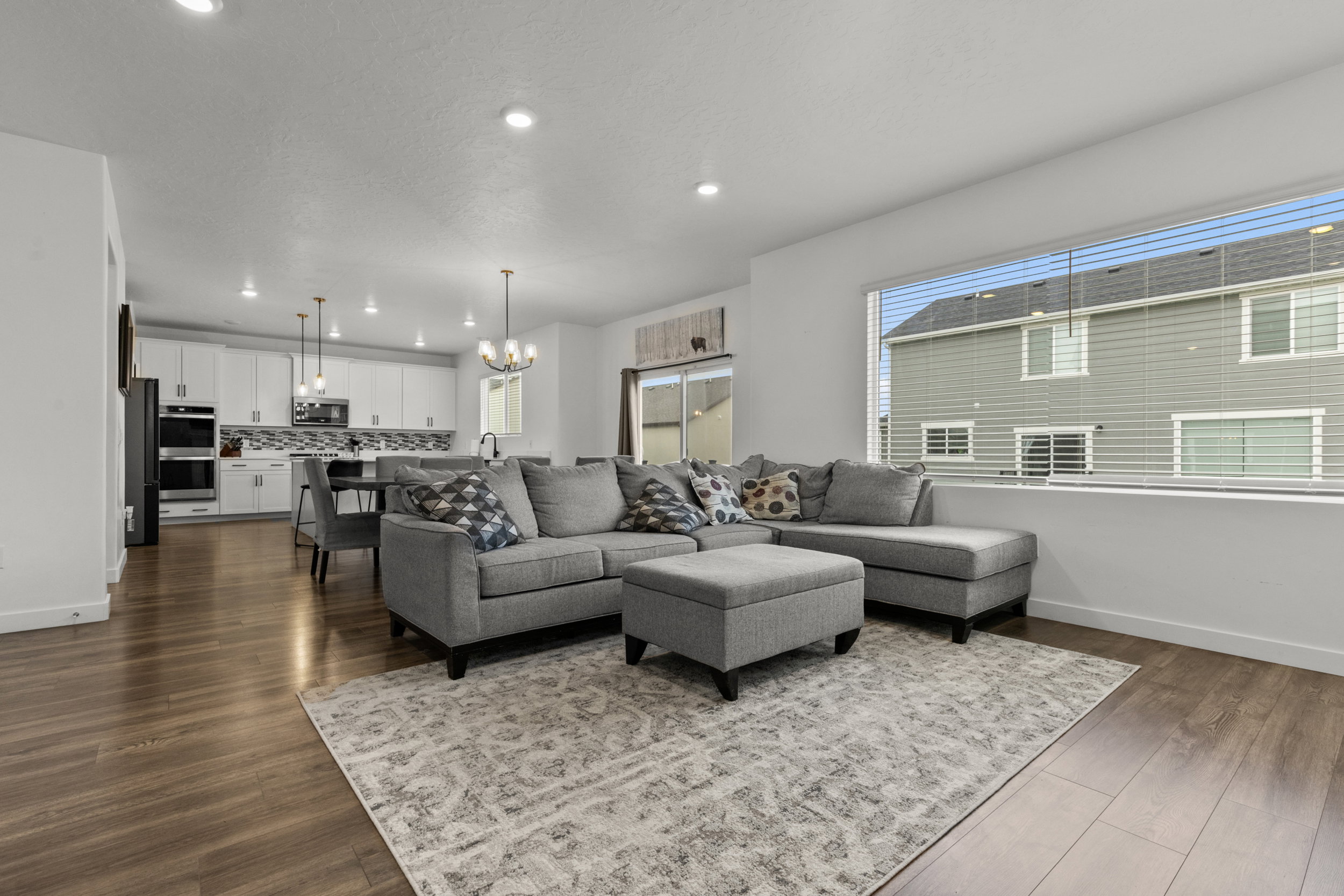 Living room with hanging lights and dark wood-style floors