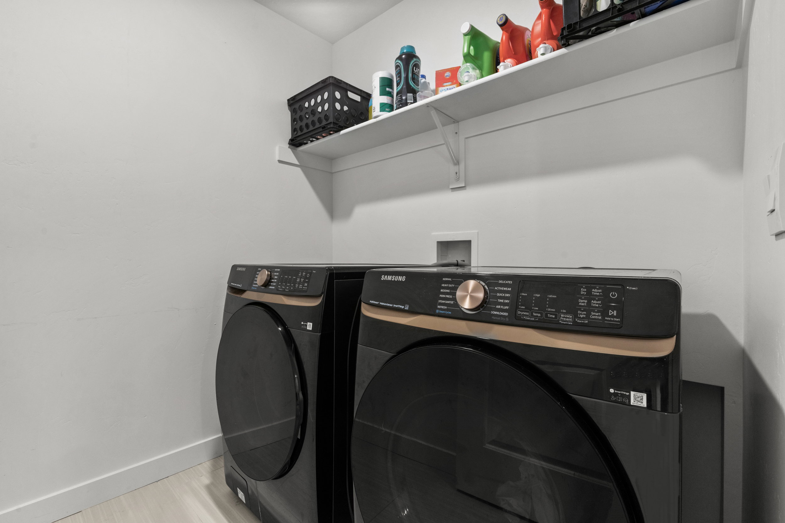 Laundry room with washer and dryer and light wood-style flooring