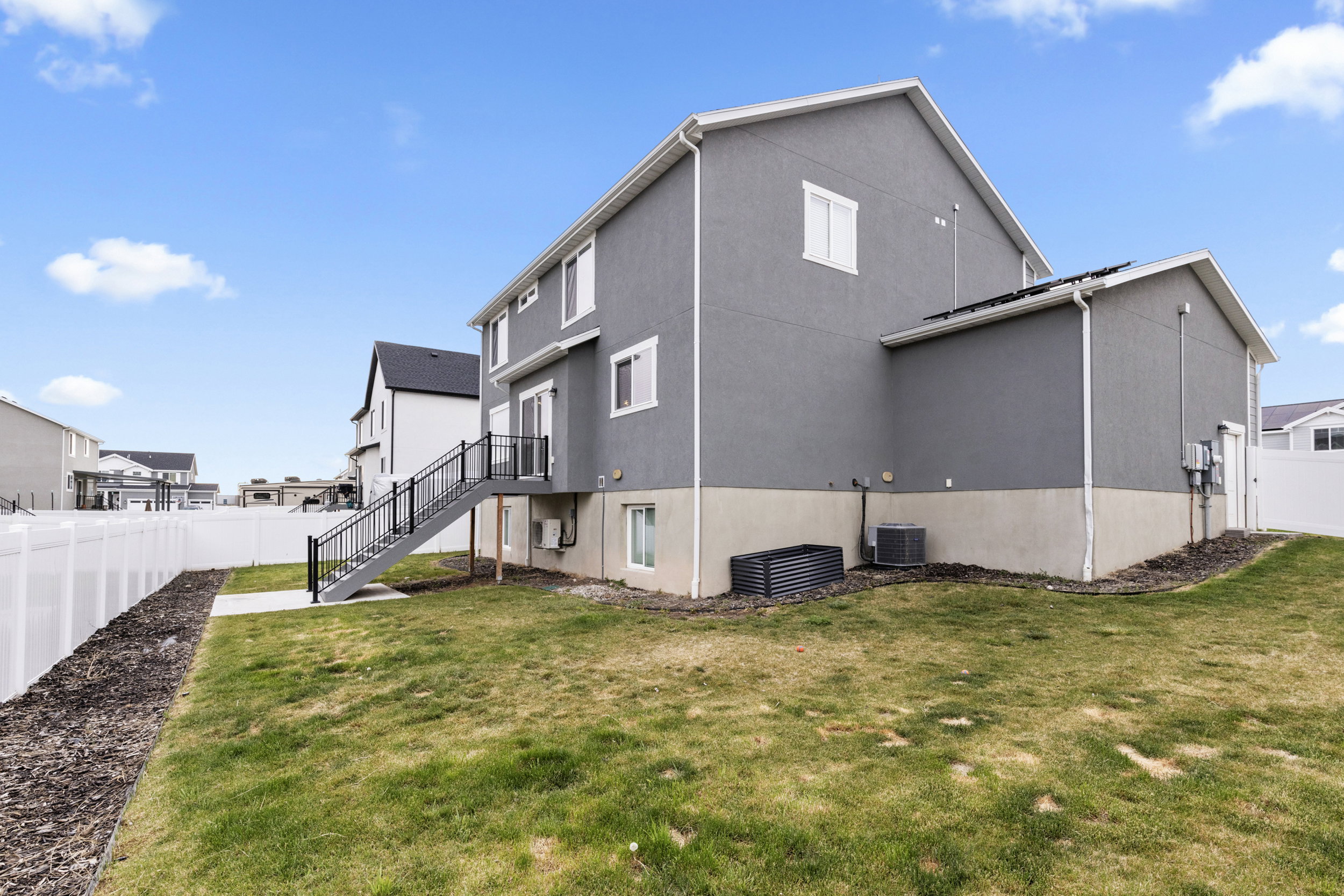Rear view of property featuring a fenced backyard and stucco siding