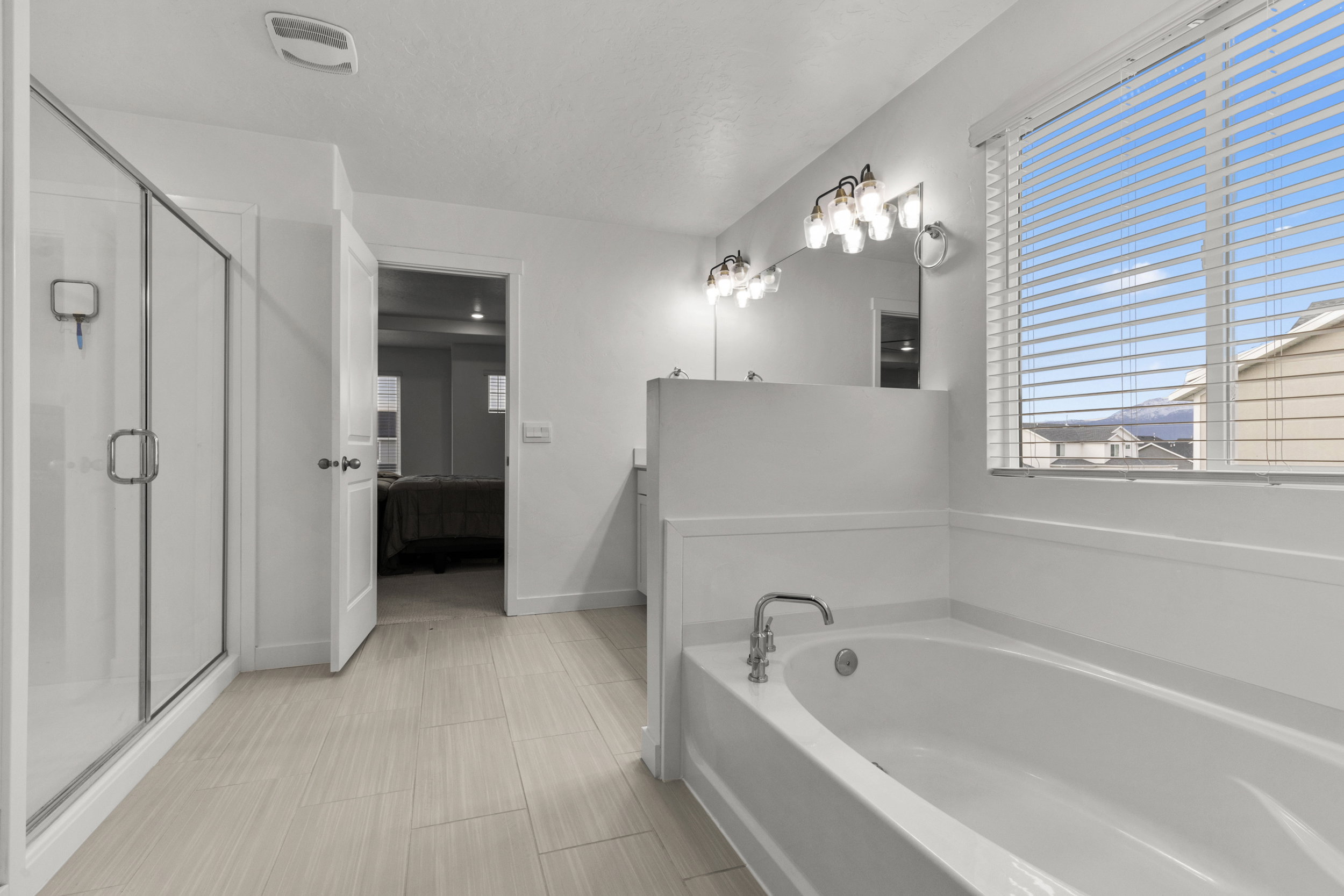 Ensuite bathroom with a shower stall, a garden tub, and vanity
