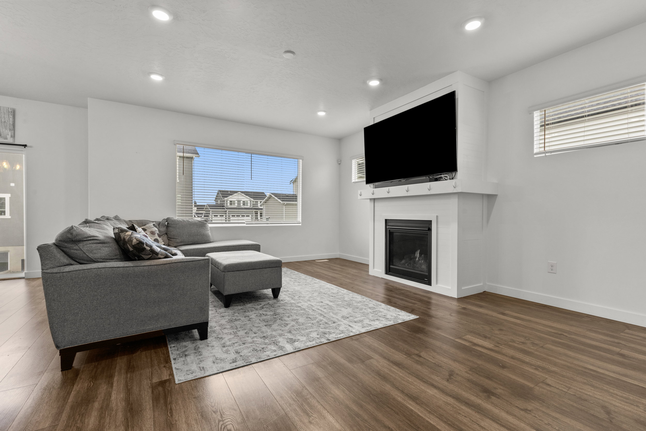 Living room featuring a glass covered fireplace, dark wood-style floors, and recessed lighting