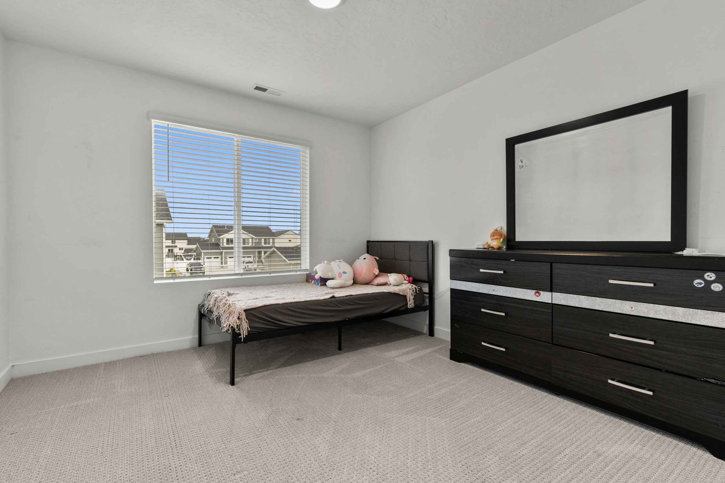 Bedroom featuring light colored carpet and baseboards