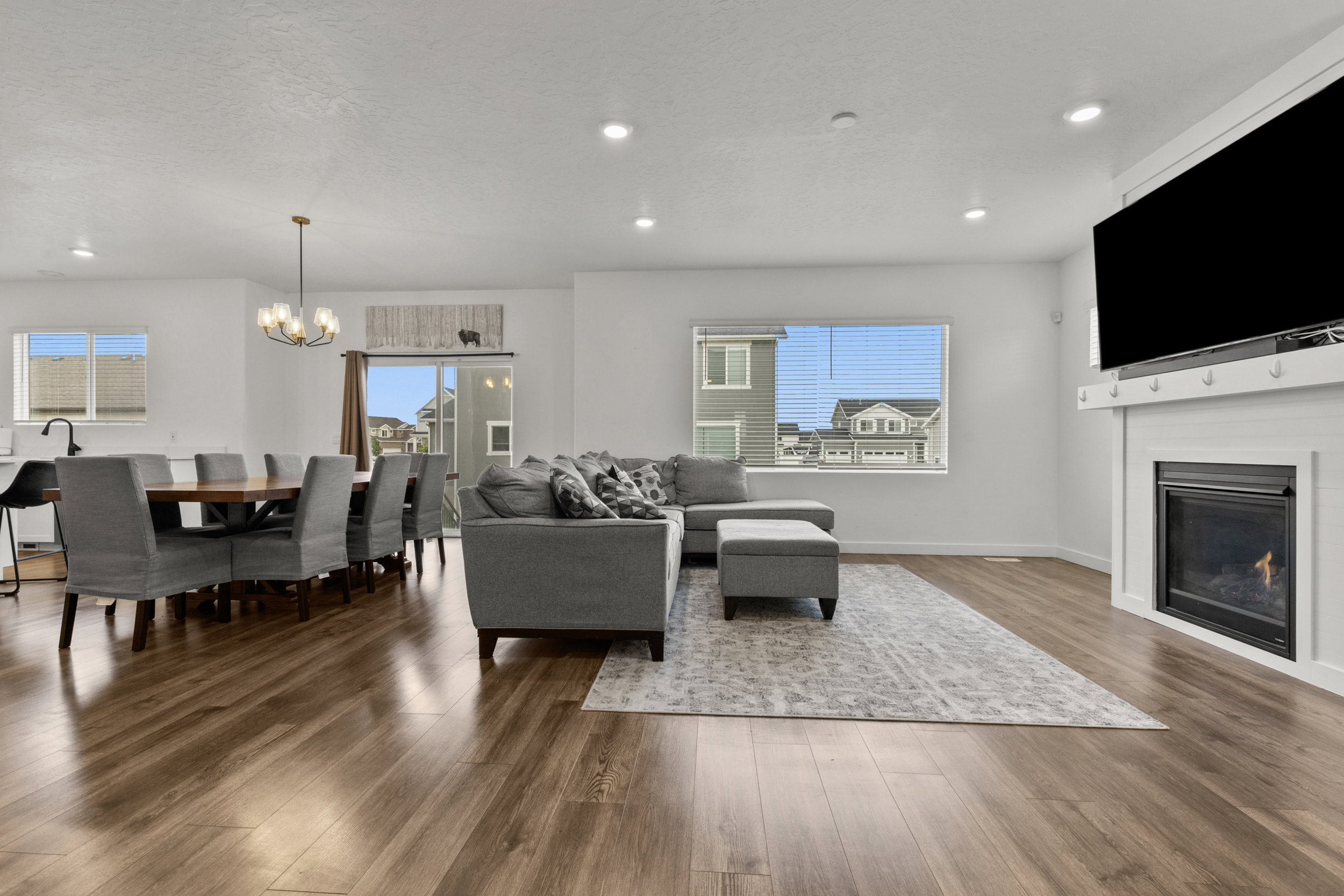 Living area featuring a glass covered fireplace, hanging lights, dark wood finished floors, healthy amount of natural light, and a textured ceiling
