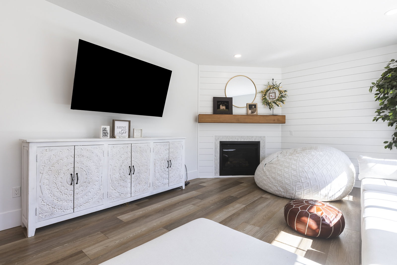 Living room with wood finished floors, recessed lighting, and a glass covered fireplace