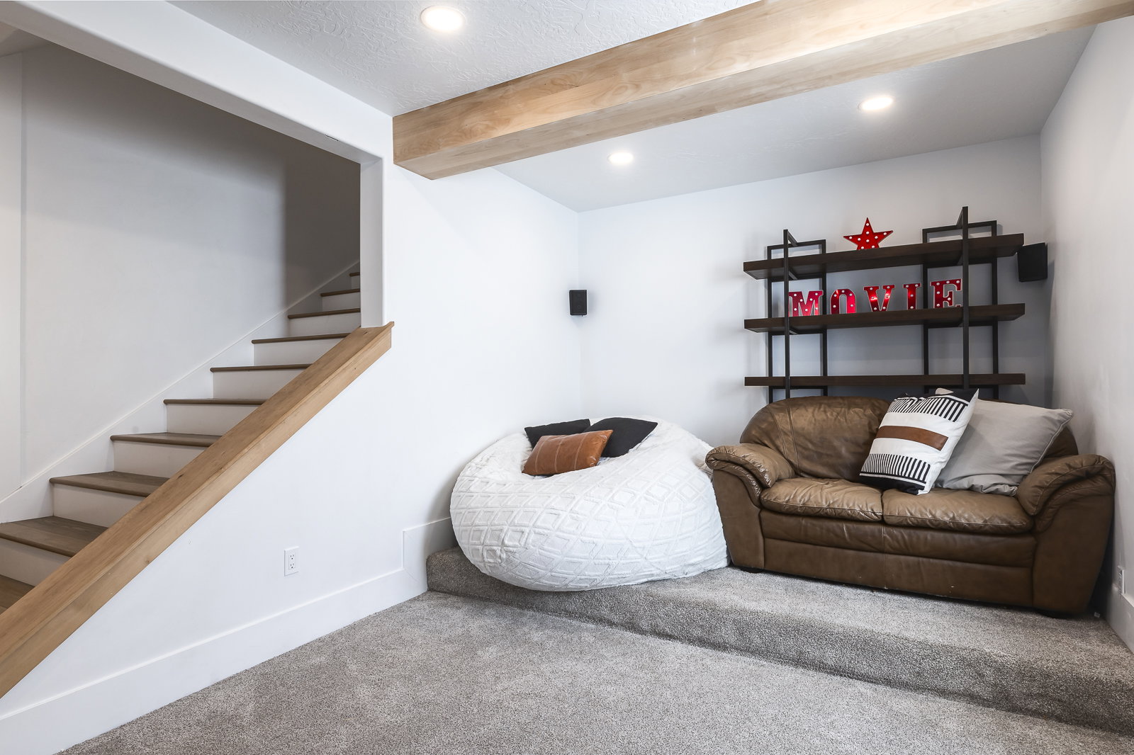 Living area with carpet flooring, beam ceiling, recessed lighting, and a textured ceiling