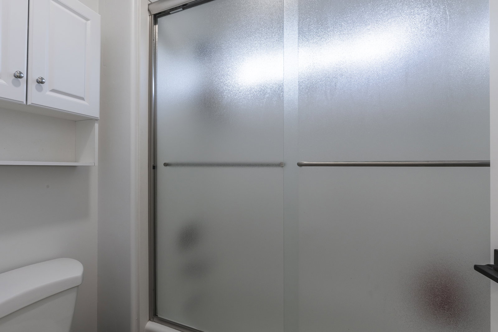 Full bath featuring toilet and combined bath / shower with glass door