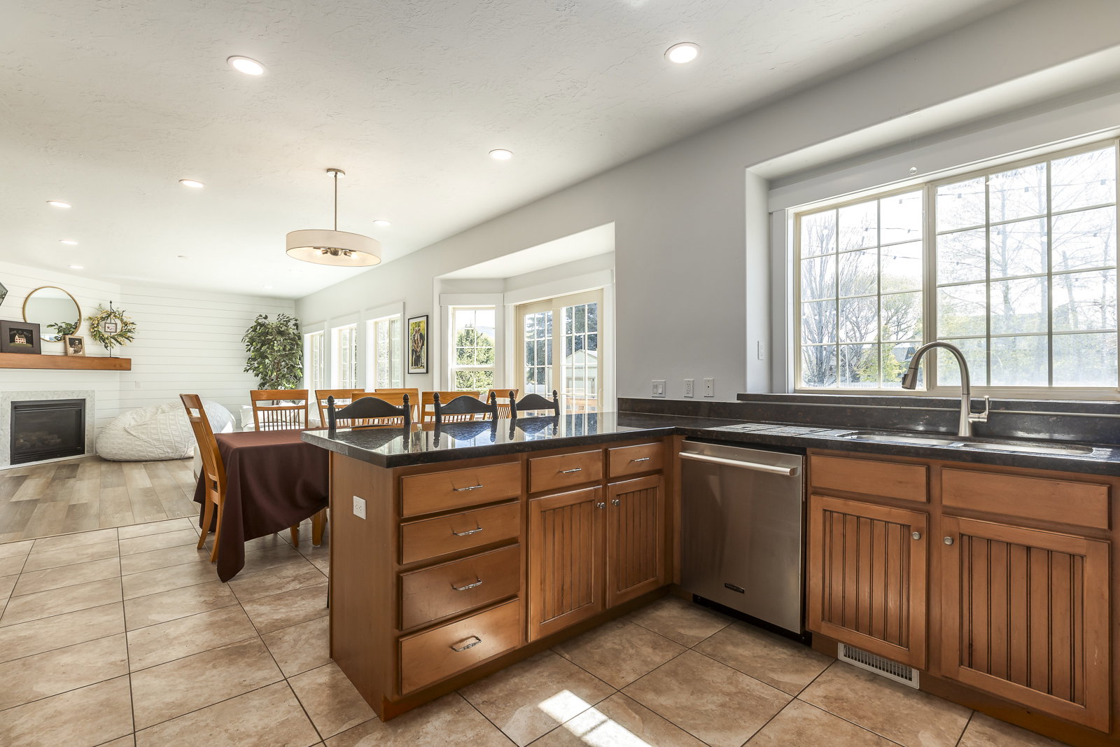 Kitchen featuring wood finish cabinets, a peninsula, a breakfast bar, open floor plan, and plenty of natural light