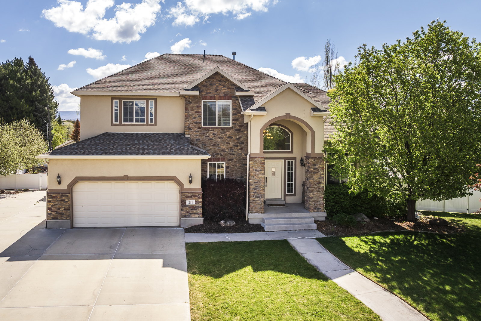 Traditional-style house with stone siding and stucco siding