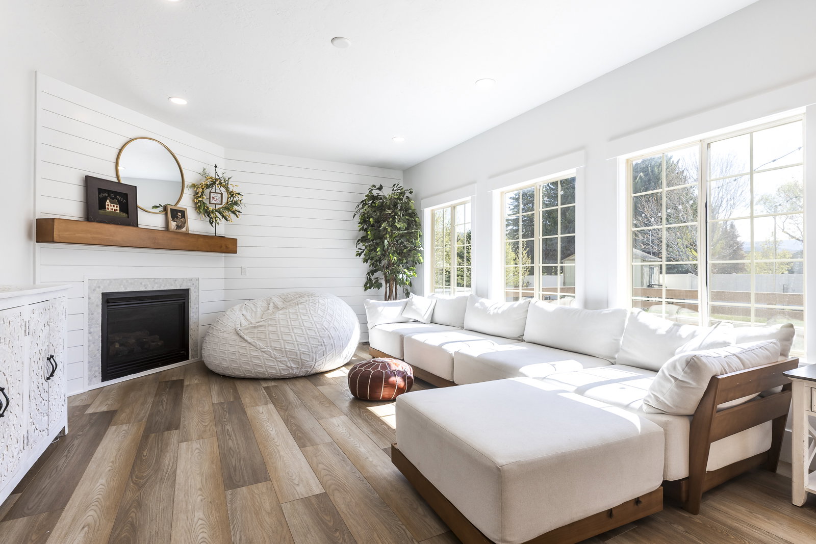 Living room featuring hardwood / wood-style floors, a glass covered fireplace, and recessed lighting