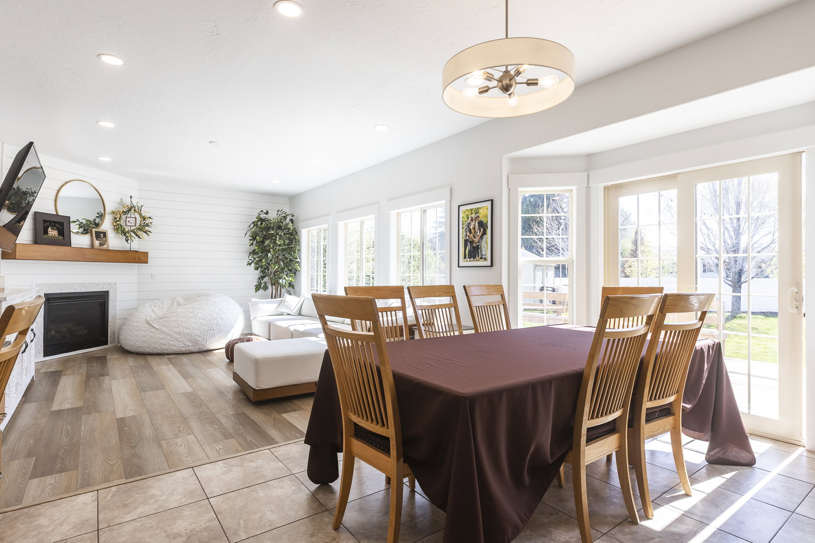 Dining room with light tile patterned floors, recessed lighting, a glass covered fireplace, and a ceiling fan